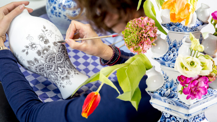Een Heinen Delfts Blauw schilder bezig aan een vaas