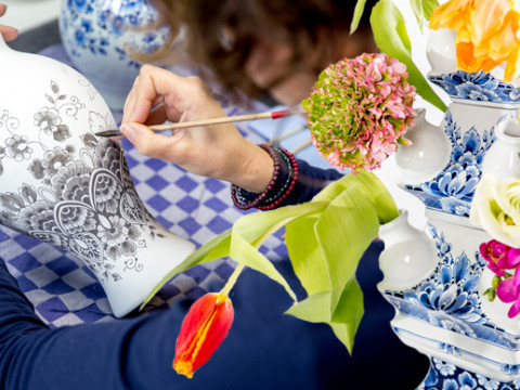Een Heinen Delfts Blauw schilder bezig aan een vaas