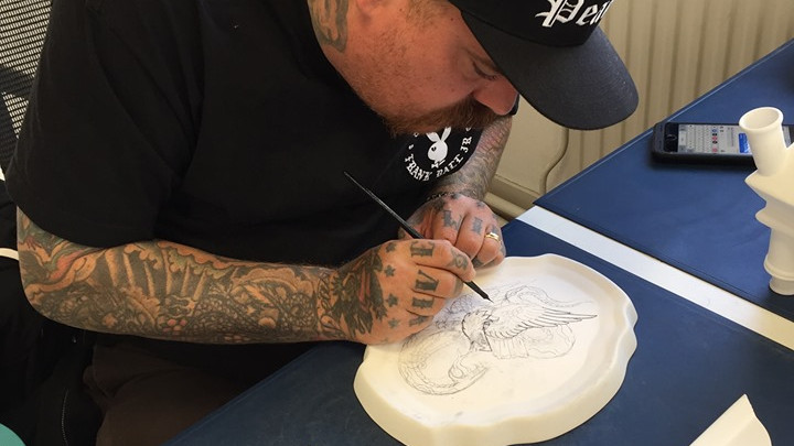 Tattoo artiest Britton aan het werk bij Heinen Delfts Blauw in Putten